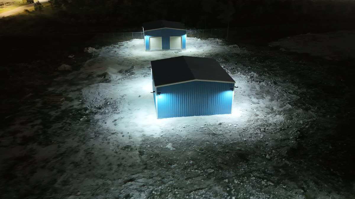 Aerial view at night of two small warehouse units, each ringed with light from JTECH solar security lights